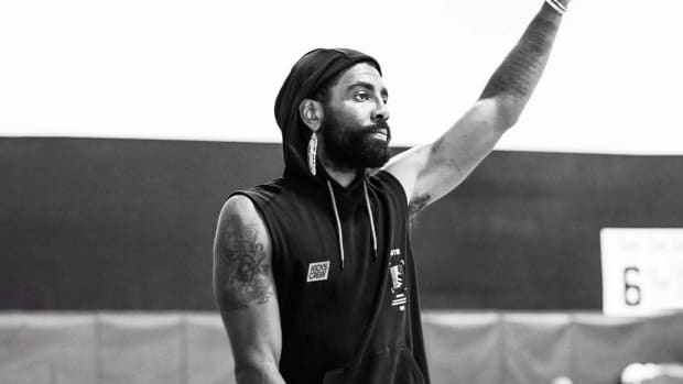 Kyrie Irving waves in a photo shoot.